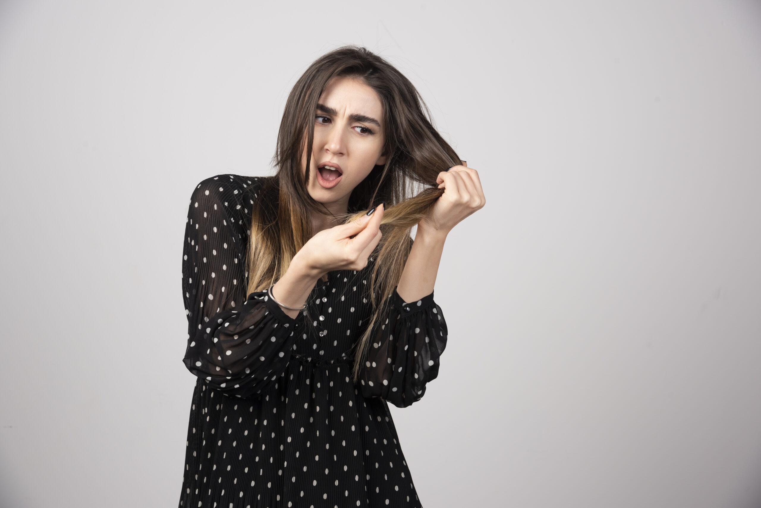 A beautiful young woman holding her healthy and shiny hair